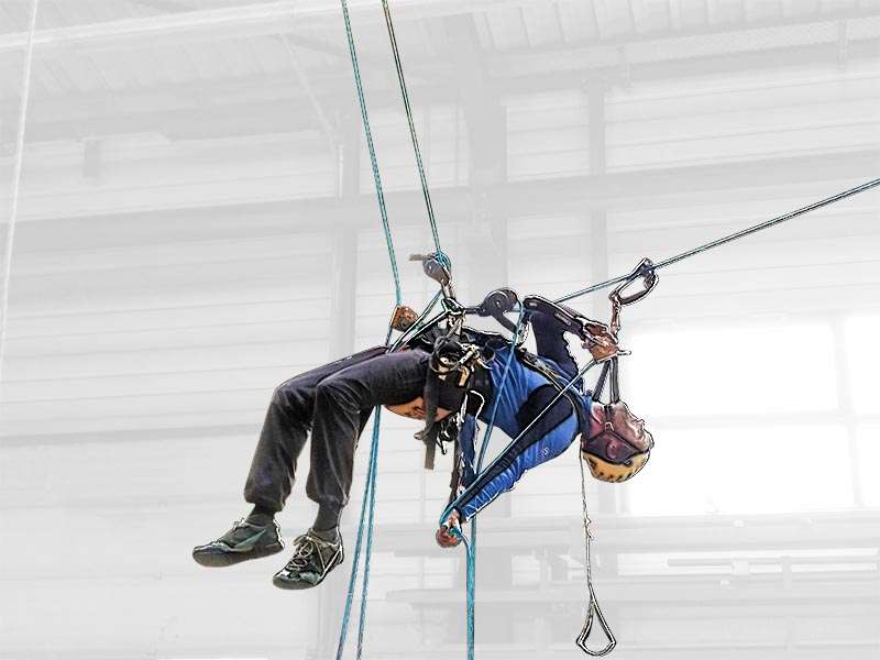 Hoehenarbeiter an Seilen hängend bei einer Rettungsübung.
