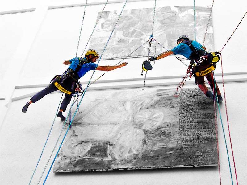 zwei Höhearbeiter im Hängen an einer Wand.